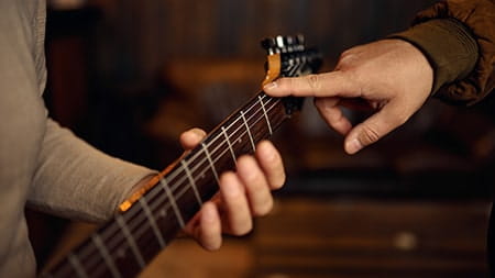 A man being taught guitar