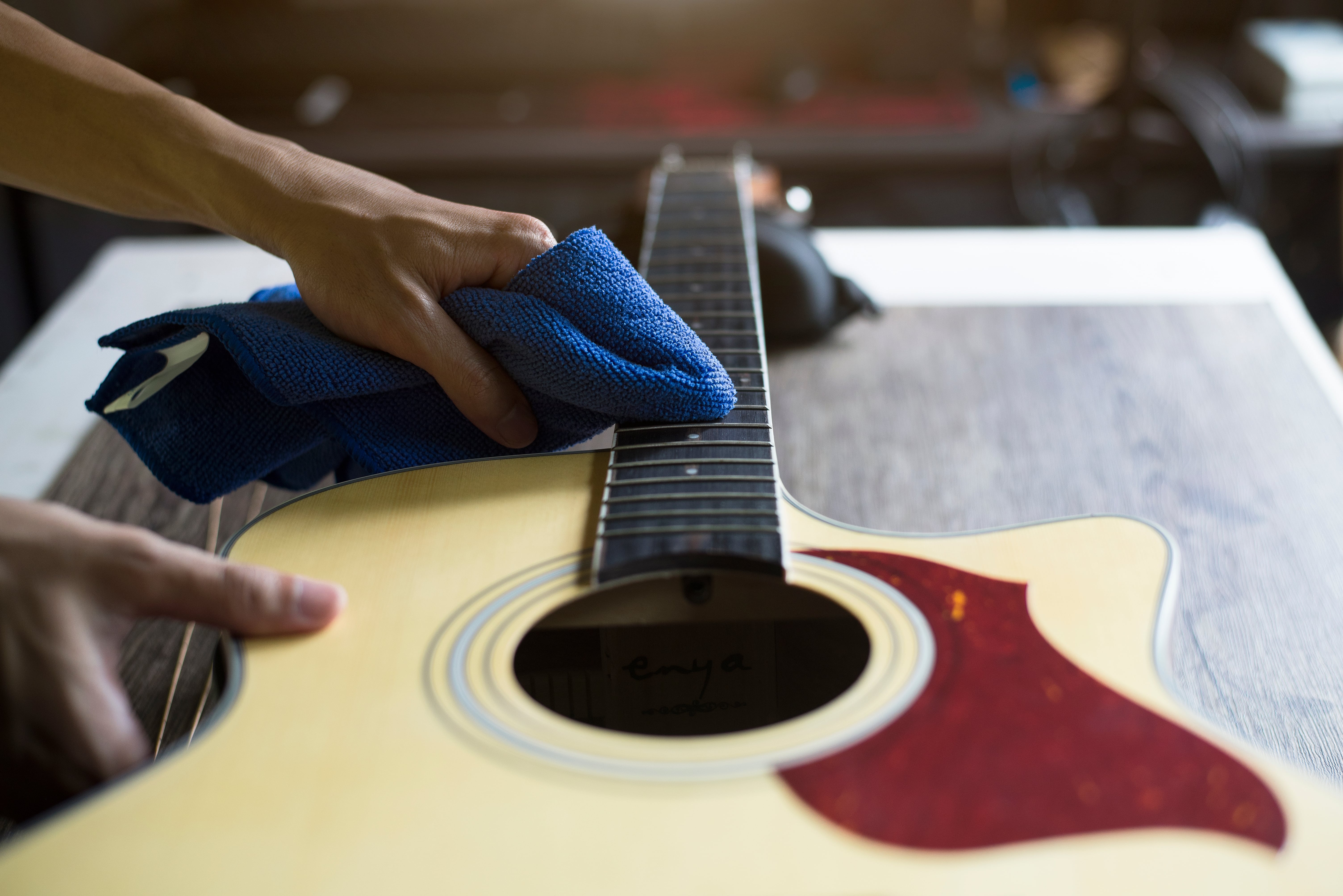 Man cleaning an acoustic guitar neck